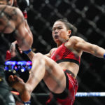 China's Zhang Weili, left, kicks Carla Esparza during the second round of a women's strawweight title bout at the UFC 281 mixed martial arts event, Saturday, Nov. 12, 2022 in New York. Zhang stopped Esparza with a rear neck choke in the second round. (AP Photo/Frank Franklin II)