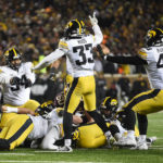 Iowa defensive lineman Yahya Black (94), defensive back Riley Moss (33) and defensive lineman Ethan Hurkett (49) celebrate after they recovered a fumble late in the second half an NCAA college football game against Minnesota on Saturday, Nov. 19, 2022, in Minneapolis. (AP Photo/Craig Lassig)
