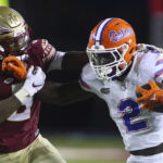 Florida running back Montrell Johnson Jr. (2) pushes off Florida State defensive back Renardo Green during the first quarter of an NCAA college football game Friday, Nov. 25, 2022, in Tallahassee, Fla. (AP Photo/Phil Sears)