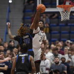 Connecticut's Tristen Newton (2) blocks a shot attempt by Buffalo's Devin Ceaser (10) in the second half of an NCAA college basketball game, Tuesday, Nov. 15, 2022, in Hartford, Conn. (AP Photo/Jessica Hill)