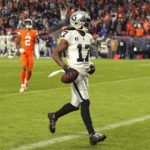 Las Vegas Raiders wide receiver Davante Adams (17) scores the winning touchdown in front of Denver Broncos cornerback Pat Surtain II (2) during overtime of an NFL football game in Denver, Sunday, Nov. 20, 2022. (AP Photo/Jack Dempsey)