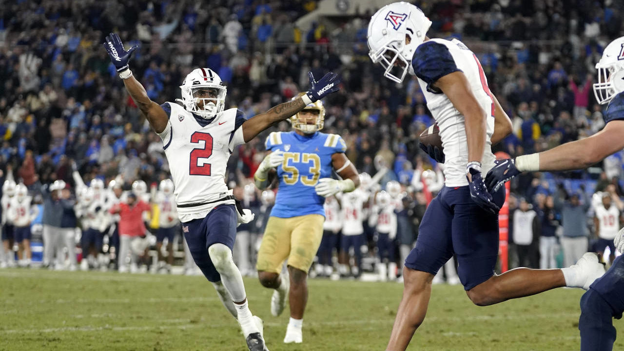Arizona wide receiver Jacob Cowing, left, celebrates a touchdown by wide receiver Tetairoa McMillan...