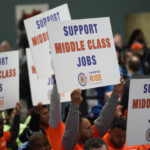 
              Union members hold up signs during an event in the Queens Museum in New York, Wednesday, Nov. 16, 2022. New York City Mayor Eric Adams was announcing the construction of a new soccer stadium, along with thousands of units of affordable housing, in the dilapidated section of Queens known as Willets Point. (AP Photo/Seth Wenig)
            
