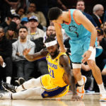 Los Angeles Lakers' Patrick Beverly (21) trips up Phoenix Suns' Devin Booker (1) as they go for a loose ball during the second half of an NBA basketball game in Phoenix, Tuesday, Nov. 22, 2022. The Phoenix Suns won the game 115-105. (AP Photo/Darryl Webb)