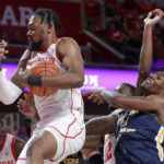 
              Houston forward J'Wan Roberts, front left, pulls down a rebound in front of Northern Colorado forward Bryce Kennedy, right, during the first half of an NCAA college basketball game Monday, Nov. 7, 2022, in Houston. (AP Photo/Michael Wyke)
            
