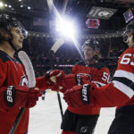 New Jersey Devils center Jack Hughes (86) is congratulated after scoring a goal by Jesper Bratt (63) and Erik Haula against the Washington Capitals during the second period of an NHL hockey game, Saturday, Nov. 26, 2022, in Newark, N.J. (AP Photo/Adam Hunger)