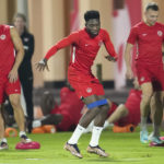 
              Canada forward Alphonso Davies, center, warms up during practice at the World Cup soccer tournament in Doha, Qatar, Tuesday, Nov. 22, 2022. (Nathan Denette/The Canadian Press via AP)
            