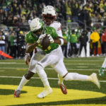 Oregon wide receiver Troy Franklin (11) hauls in a touchdown pass in front of Utah cornerback Clark Phillips III (1) during the first half of an NCAA college football game Saturday, Nov. 19, 2022, in Eugene, Ore. (AP Photo/Andy Nelson)