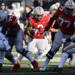 Ohio State running back Miyan Williams, center, runs against Michigan during the first half of an NCAA college football game on Saturday, Nov. 26, 2022, in Columbus, Ohio. (AP Photo/Jay LaPrete)