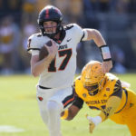 
              Oregon State quarterback Ben Gulbranson runs with the ball as Arizona State defensive lineman B.J. Green II, right, dives for the tackle during the first half of an NCAA college football game in Tempe, Ariz., Saturday, Nov. 19, 2022. (AP Photo/Ross D. Franklin)
            