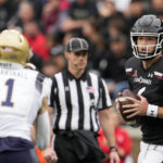 Cincinnati quarterback Ben Bryant, right, looks to pass the ball during the first half of an NCAA college football game against Navy, Saturday, Nov. 5, 2022, in Cincinnati. (AP Photo/Jeff Dean)