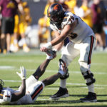 Oregon State offensive lineman Jake Levengood tries to stretch the calf of teammate Oregon State wide receiver Tyjon Lindsey (1) during the second half of an NCAA college football game against Arizona State in Tempe, Ariz., Saturday, Nov. 19, 2022. Oregon State won 31-7. (AP Photo/Ross D. Franklin)