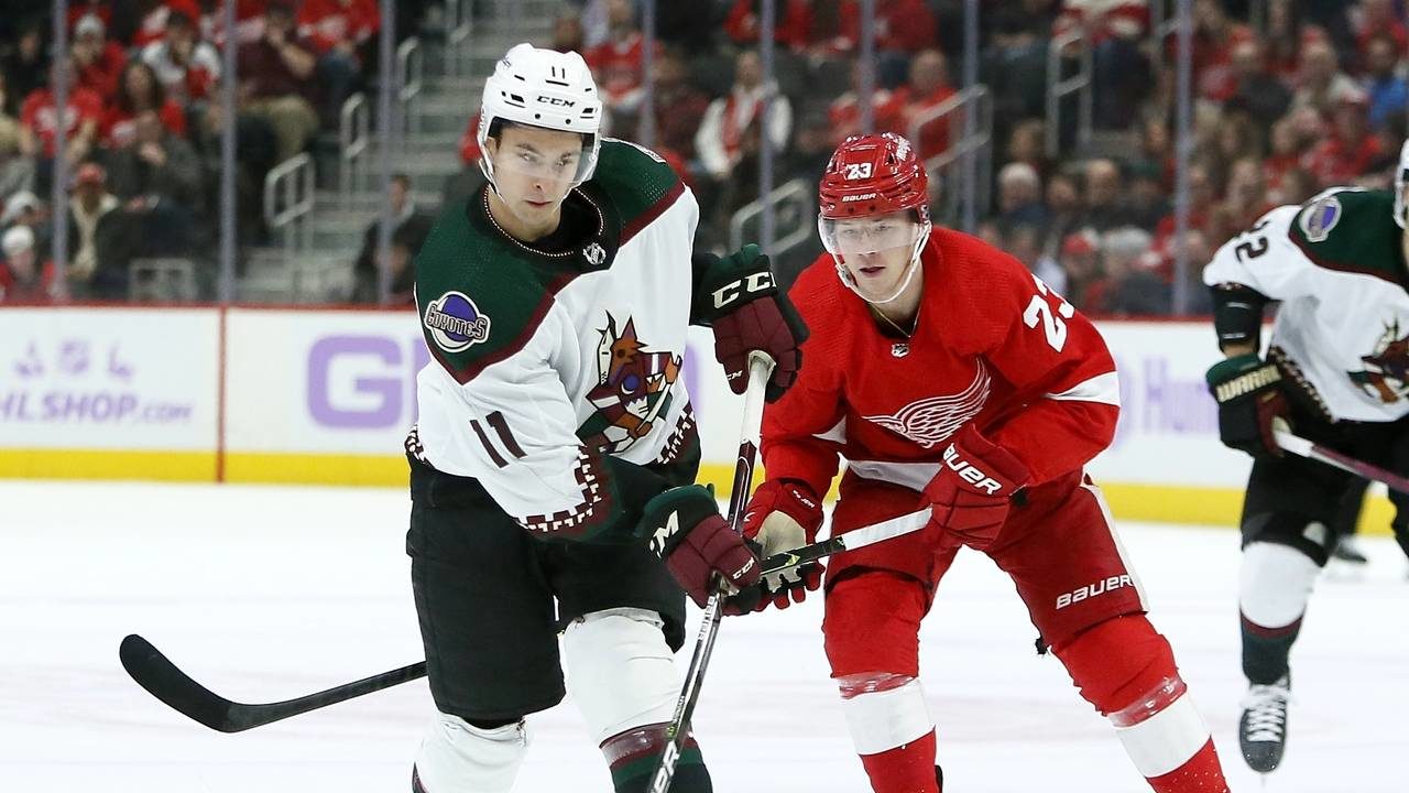 Arizona Coyotes right wing Dylan Guenther (11) shoots while pursued by Detroit Red Wings left wing ...