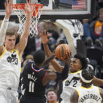 
              Los Angeles Clippers guard John Wall (11) shoots as Utah Jazz's Lauri Markkanen (23) and Collin Sexton (2) defend during the first half of an NBA basketball game Wednesday, Nov. 30, 2022, in Salt Lake City. (AP Photo/Rick Bowmer)
            