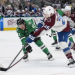 Colorado Avalanche' Jacob MacDonald (26) takes a shot as Dallas Stars left wing Mason Marchment (27) defends in the second period of an NHL hockey game Monday, Nov. 21, 2022, in Dallas. (AP Photo/Tony Gutierrez)