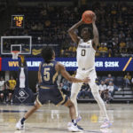 
              West Virginia guard Kedrian Johnson (0) is defended by Mount St. Mary's guard Jalen Benjamin (5) during the second half of an NCAA college basketball game in Morgantown, W.Va., Monday, Nov. 7, 2022. (AP Photo/Kathleen Batten)
            