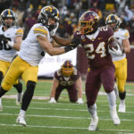 Minnesota running back Mohamed Ibrahim (24) stiff-arms Iowa defensive back Cooper DeJean (3) during the first half an NCAA college football game on Saturday, Nov. 19, 2022, in Minneapolis. (AP Photo/Craig Lassig)