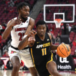Appalachian State forward Donovan Gregory (11) drives around Louisville forward Jae'Lyn Withers (24) during the first half of an NCAA college basketball game in Louisville, Ky., Tuesday, Nov. 15, 2022. (AP Photo/Timothy D. Easley)