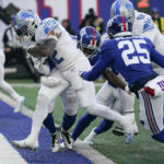 Detroit Lions running back D'Andre Swift (32) runs in a touchdown against New York Giants linebacker Tae Crowder (48) during the second half of an NFL football game, Sunday, Nov. 20, 2022, in East Rutherford, N.J. (AP Photo/Seth Wenig)
