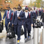 
              Arizona football players arrive at Rice-Eccles Stadium before their NCAA college football game against Utah Saturday, Nov. 5, 2022, in Salt Lake City. College athletic programs of all sizes are reacting to inflation the same way as everyone else. They're looking for ways to save. Arizona estimates it could spend $4 million more across the board this year than it would if the U.S. inflation rate hadn’t risen to more than 8%. (AP Photo/Rick Bowmer)
            