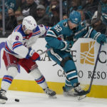 
              New York Rangers defenseman Zac Jones, left, and San Jose Sharks right wing Kevin Labanc (62) look for the puck during the first period of an NHL hockey game in San Jose, Calif., Saturday, Nov. 19, 2022. (AP Photo/Jeff Chiu)
            