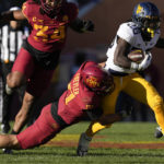 
              West Virginia running back Justin Johnson Jr. (26) tries to break a tackle by Iowa State defensive back Beau Freyler (17) during the first half of an NCAA college football game, Saturday, Nov. 5, 2022, in Ames, Iowa. (AP Photo/Charlie Neibergall)
            