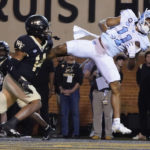 
              North Carolina wide receiver Josh Downs (11) catches a touchdown pass as Wake Forest defensive back Evan Slocum (14) defends during the first half of an NCAA college football game in Winston-Salem, N.C., Saturday, Nov. 12, 2022. (AP Photo/Chuck Burton)
            