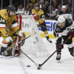 Arizona Coyotes right wing Christian Fischer (36) moves the puck around the net as Vegas Golden Knights defenseman Nicolas Hague (14) defends during the first period of an NHL hockey game Thursday, Nov. 17, 2022, in Las Vegas. (AP Photo/Sam Morris)