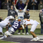 
              Kansas State running back Deuce Vaughn (22) scores a touchdown while being tackled by Texas defensive back Kitan Crawford, left, and Texas defensive back Jerrin Thompson, right, during the first half of an NCAA college football game Saturday, Nov. 5, 2022, in Manhattan, Kan. (AP Photo/Reed Hoffmann)
            
