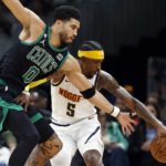 
              Boston Celtics' Jayson Tatum (0) battles Denver Nuggets' Kentavious Caldwell-Pope (5) for the ball during the first half of an NBA basketball game, Friday, Nov. 11, 2022, in Boston. (AP Photo/Michael Dwyer)
            