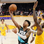 
              Portland Trail Blazers guard Anfernee Simons, second from left, shoots as Los Angeles Lakers forward LeBron James defends during the first half of an NBA basketball game Wednesday, Nov. 30, 2022, in Los Angeles. (AP Photo/Mark J. Terrill)
            