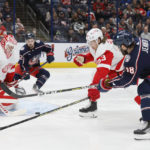 Detroit Red Wings' Ville Husso, left, makes a save as teammate Moritz Seider, center, defends against Columbus Blue Jackets' Boone Jenner during the second period of an NHL hockey game, Saturday, Nov. 19, 2022, in Columbus, Ohio. (AP Photo/Jay LaPrete)