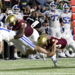 Duke quarterback Riley Leonard is tackled by Boston College defensemen Kam Arnold (5) and Cole Batson (23) during the first half of an NCAA college football game, Friday, Nov. 4, 2022 in Boston. (AP Photo/Mark Stockwell)