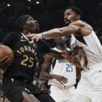 Toronto Raptors forward Chris Boucher, left, looks to the basket as he drives toward Dallas Mavericks' Spencer Dinwiddie during first-half NBA basketball game action in Toronto, Saturday, Nov. 26, 2022. (Chris Young/The Canadian Press via AP)