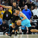 
              Phoenix Suns guard Devin Booker drives as Golden State Warriors guard Stephen Curry, left, defends during the first half of an NBA basketball game, Wednesday, Nov. 16, 2022, in Phoenix. (AP Photo/Matt York)
            
