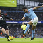 Fulham's Tim Ream, left, tries to block a shot from Manchester City's Ilkay Gundogan during the English Premier League soccer match between Manchester City and Fulham at Etihad stadium in Manchester, England, Saturday, Nov. 5, 2022. (AP Photo/Dave Thompson)