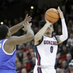 Gonzaga guard Julian Strawther (0) shoots while defended by Kentucky guard Sahvir Wheeler (2) during the first half of an NCAA college basketball game, Sunday, Nov. 20, 2022, in Spokane, Wash. (AP Photo/Young Kwak)