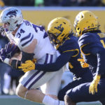 Kansas State tight end Ben Sinnott (34) is defended by West Virginia safetys Marcis Floyd and Malachi Ruffin (14) during the first half of an NCAA college football game in Morgantown, W.Va., Saturday, Nov. 19, 2022. (AP Photo/Kathleen Batten)