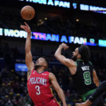 New Orleans Pelicans guard CJ McCollum (3) drives to the basket against Boston Celtics guard Derrick White (9) in the first half of an NBA basketball game in New Orleans, Friday, Nov. 18, 2022. (AP Photo/Gerald Herbert)
