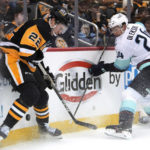
              Pittsburgh Penguins' Sam Poulin (22) works to control the puck against Seattle Kraken's Jamie Oleksiak during the second period of an NHL hockey game in Pittsburgh, Saturday, Nov. 5, 2022. (AP Photo/{Gene J. Puskar})
            
