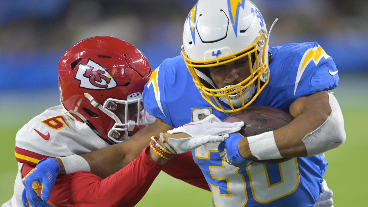 Los Angeles Chargers running back Austin Ekeler, right, is tackled by Kansas City Chiefs safety Bry...