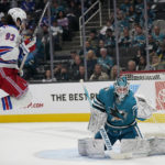 San Jose Sharks goaltender James Reimer, right, watches as the puck passes the side of the net in front of New York Rangers center Mika Zibanejad (93) during the second period of an NHL hockey game in San Jose, Calif., Saturday, Nov. 19, 2022. (AP Photo/Jeff Chiu)