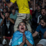 A fan of Argentina reacts after Argentina's Lionel Messi scores his side's opening goal against Mexico as she watch on a giant screen during a World Cup group C soccer match between Argentina and Mexico at the FIFA Fan Festival in Doha, Qatar, Saturday, Nov. 26, 2022. (AP Photo/Manu Fernandez)