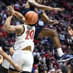 
              Cal State Fullerton forward Garrison Wade, top, blocks a shot by San Diego State guard Matt Bradley (20) during the first half of an NCAA college basketball game Monday, Nov. 7, 2022, in San Diego. (AP Photo/Denis Poroy)
            