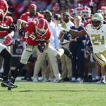 
              Georgia wide receiver Ladd McConkey (84) returns a punt as Georgia Tech defensive back Kenan Johnson (24) closes in during the first half of an NCAA college football game Saturday, Nov. 26, 2022 in Athens, Ga. (AP Photo/John Bazemore)
            