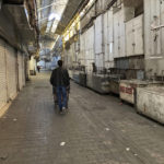 
              A man pushes his cart past closed shops of Tehran's Grand Bazaar, Iran, Tuesday, Nov. 15, 2022.  Many shops at Grand Bazaar in Iran's capital city were closed Tuesday amid strike calls following the September death of a woman who was arrested by the country's morality police.  (AP Photo/Vahid Salemi)
            
