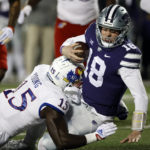 Kansas State quarterback Will Howard (18) is tackled by Kansas linebacker Craig Young (15) after scrambling for a first down during the first quarter of an NCAA college football game Saturday, Nov. 26, 2022, in Manhattan, Kan. (AP Photo/Colin E. Braley)