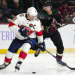 Florida Panthers center Aleksander Barkov (16) keeps the puck away from Arizona Coyotes defenseman Josh Brown, right, during the third period of an NHL hockey game in Tempe, Ariz., Tuesday, Nov. 1, 2022. The Coyotes won 3-1. (AP Photo/Ross D. Franklin)