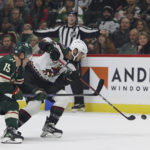 
              Arizona Coyotes defenseman Shayne Gostisbehere (14) handles the puck against Minnesota Wild center Mason Shaw (15) during the first period of an NHL hockey game Sunday, Nov. 27, 2022, in St. Paul, Minn. (AP Photo/Stacy Bengs)
            