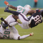 
              Houston Texans tight end Jordan Akins (88) fumbles the ball after colliding with Miami Dolphins safety Eric Rowe (21) and cornerback Kader Kohou (28) during the first half of an NFL football game, Sunday, Nov. 27, 2022, in Miami Gardens, Fla. The fumble lead to a Miami Dolphins touchdown. (AP Photo/Michael Laughlin)
            